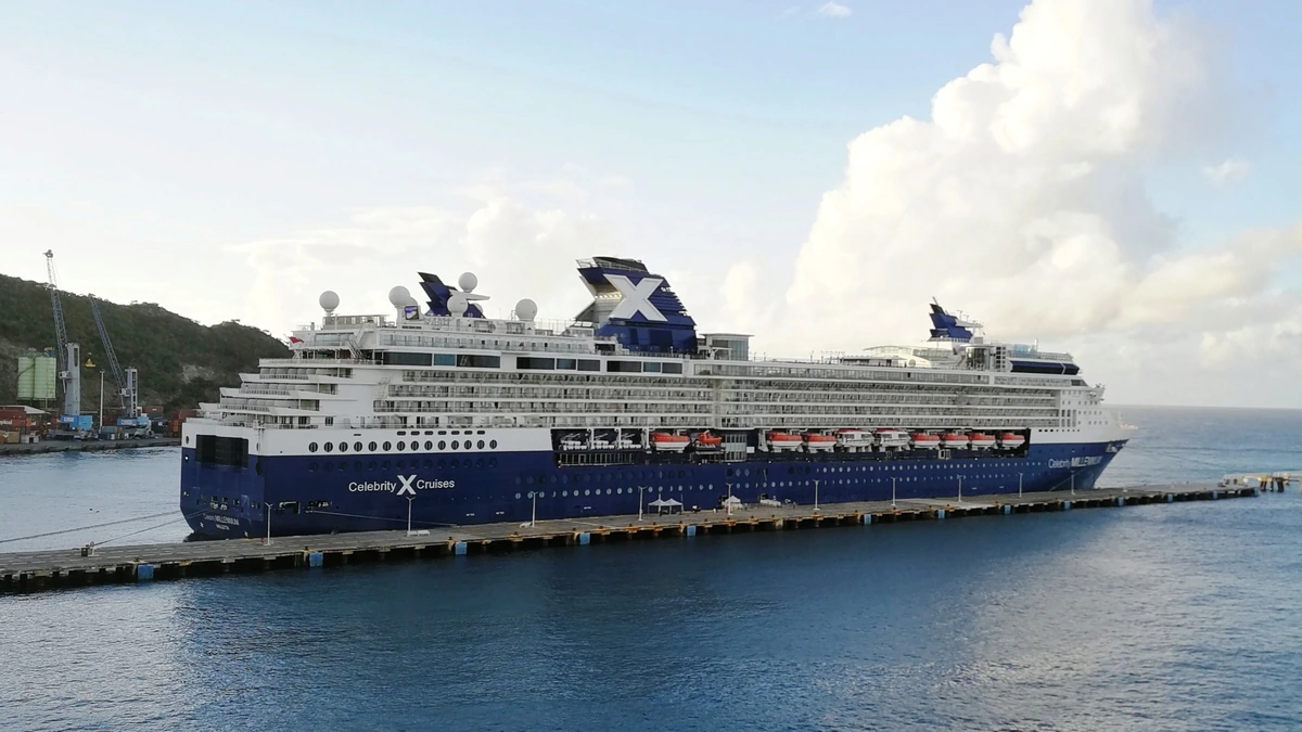 Celebrity Millennium cruise ship docked at Philipsburg, St Maarten, beside a long pier in blue harbour water.