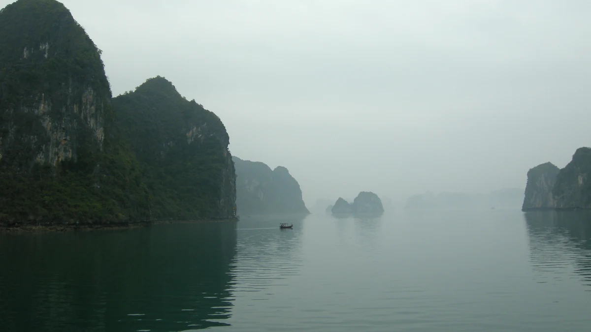Limestone islands rising from misty water in Ha Long Bay, Vietnam