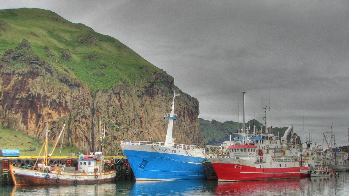 Heimaey cruise port harbour beneath volcanic cliffs in Iceland