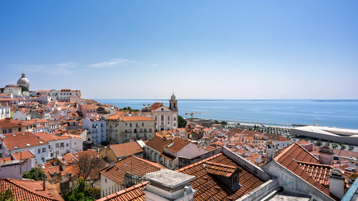 Lisbon cruise port guide image showing Alfama rooftops and the Tagus River in Lisbon