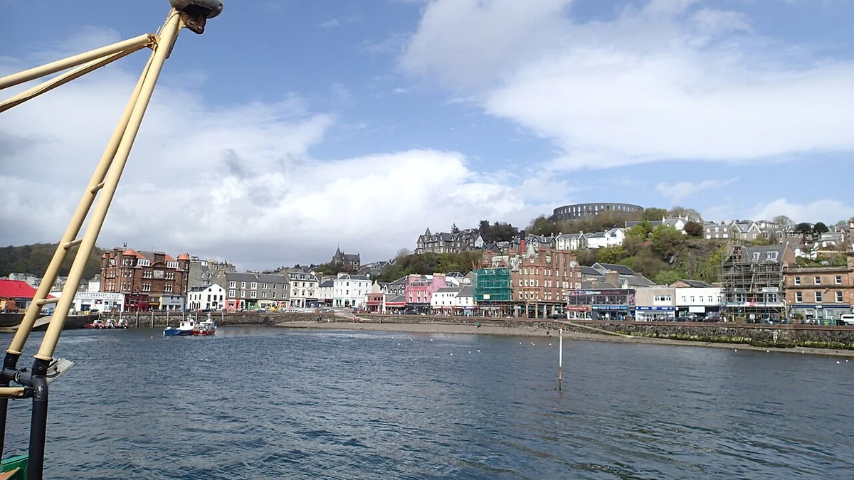 Oban cruise port harbour with McCaig’s Tower above the town