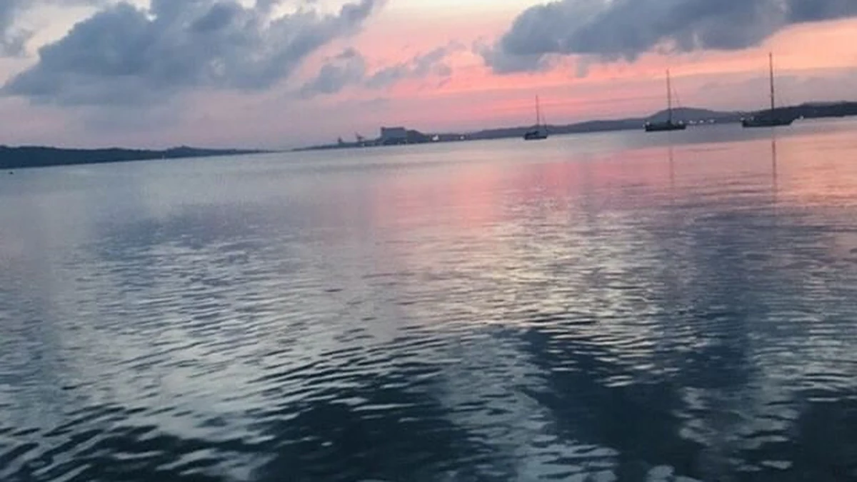 Calm water and boats at sunset in Trincomalee natural harbour, Sri Lanka